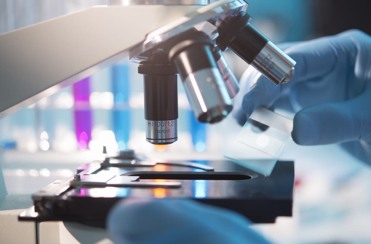 Closeup of researcher placing slide on microscope