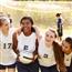 five young ladies posing for picture on soccer field