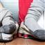 Sock covered feet resting on top of sneakers