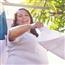 Woman and young boy folding up a white towel outside